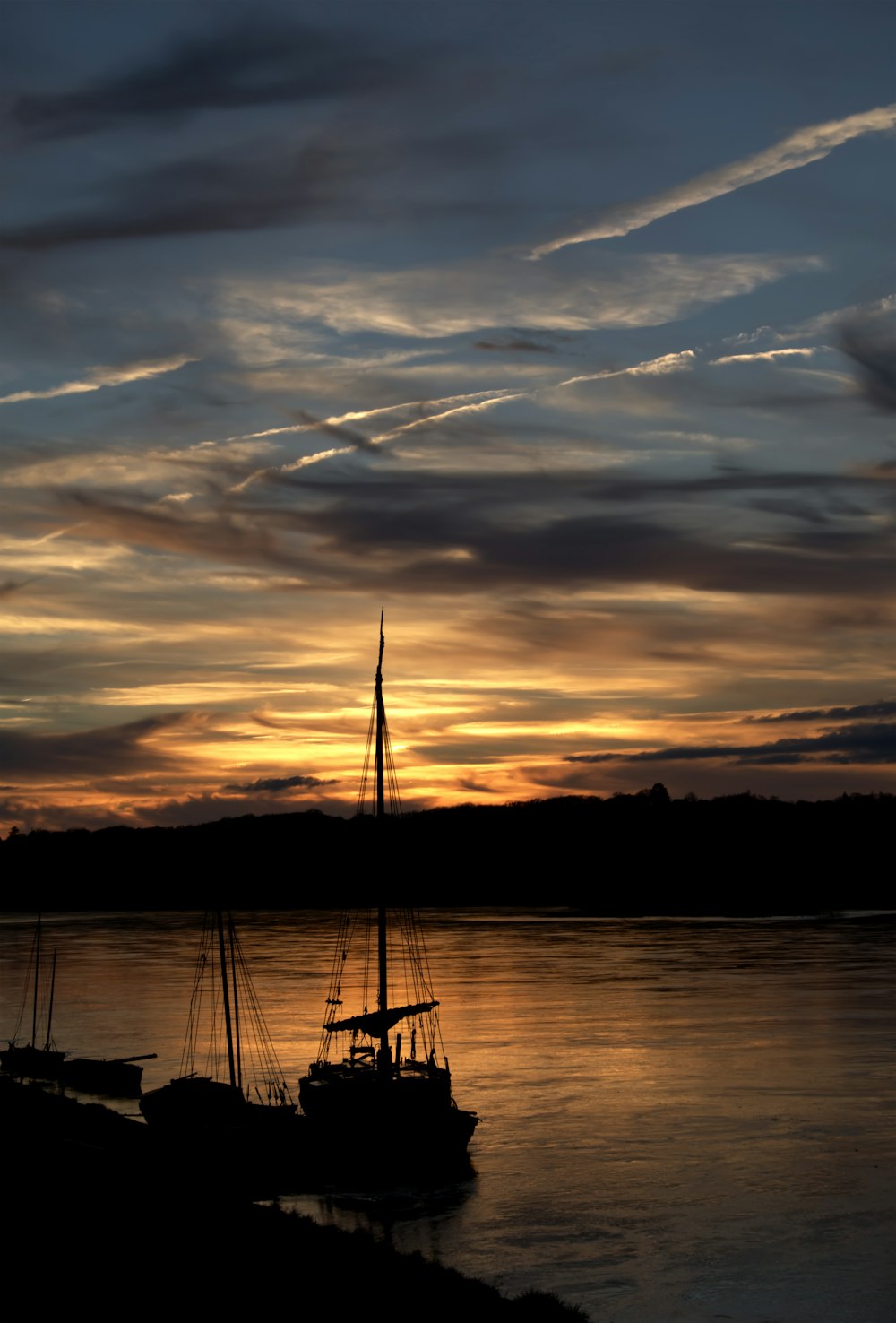 silhouette of boat on sea during sunset