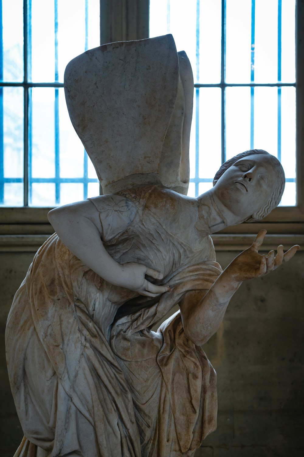 angel statue near brown wooden window