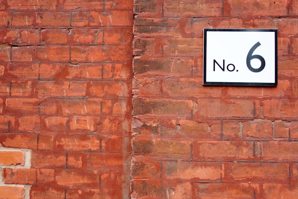 black and white no smoking sign on brown brick wall