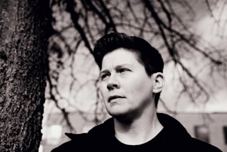 Black and white portrait of a transgender person looking thoughtfully into the distance.