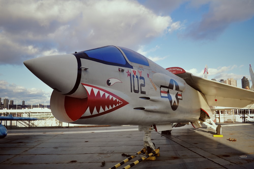 white and red jet plane on gray wooden dock during daytime