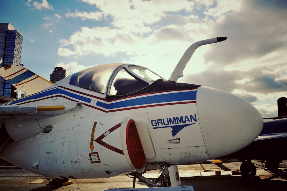 white and blue airplane under white clouds during daytime