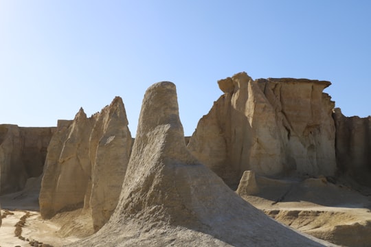 brown rock formation under blue sky during daytime in Qeshm Iran