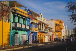 cars parked in front of green and white concrete building during daytime