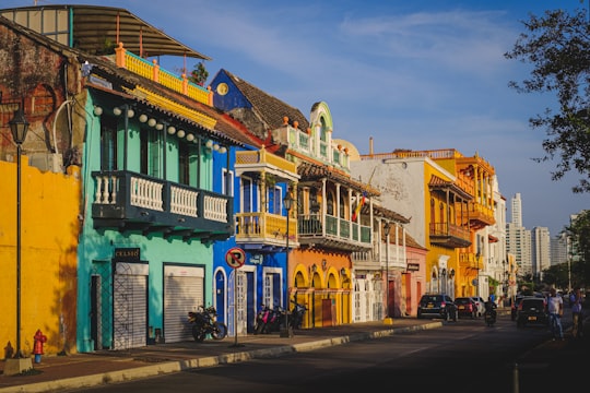 cars parked in front of green and white concrete building during daytime in Cartagena Colombia