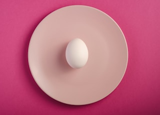 white round plate on pink textile