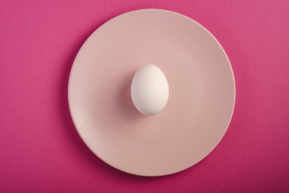 white round plate on pink textile