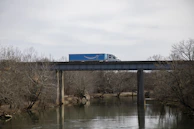 Diamond Transport truck crossing a scenic bridge under a clear blue sky.