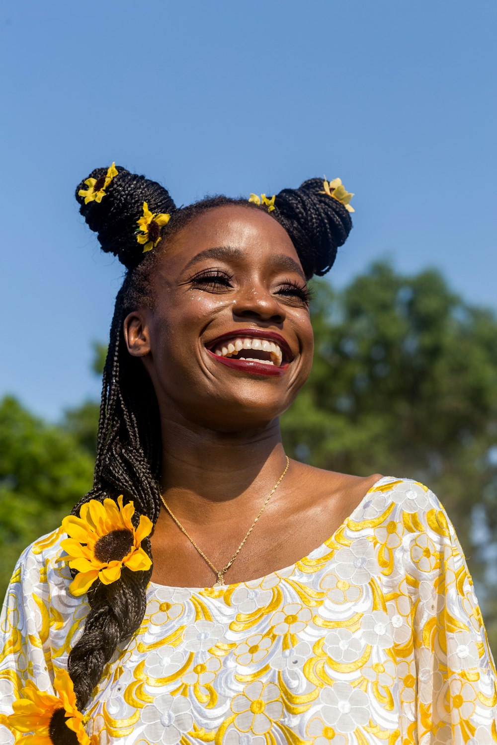 smiling woman in yellow and white floral shirt