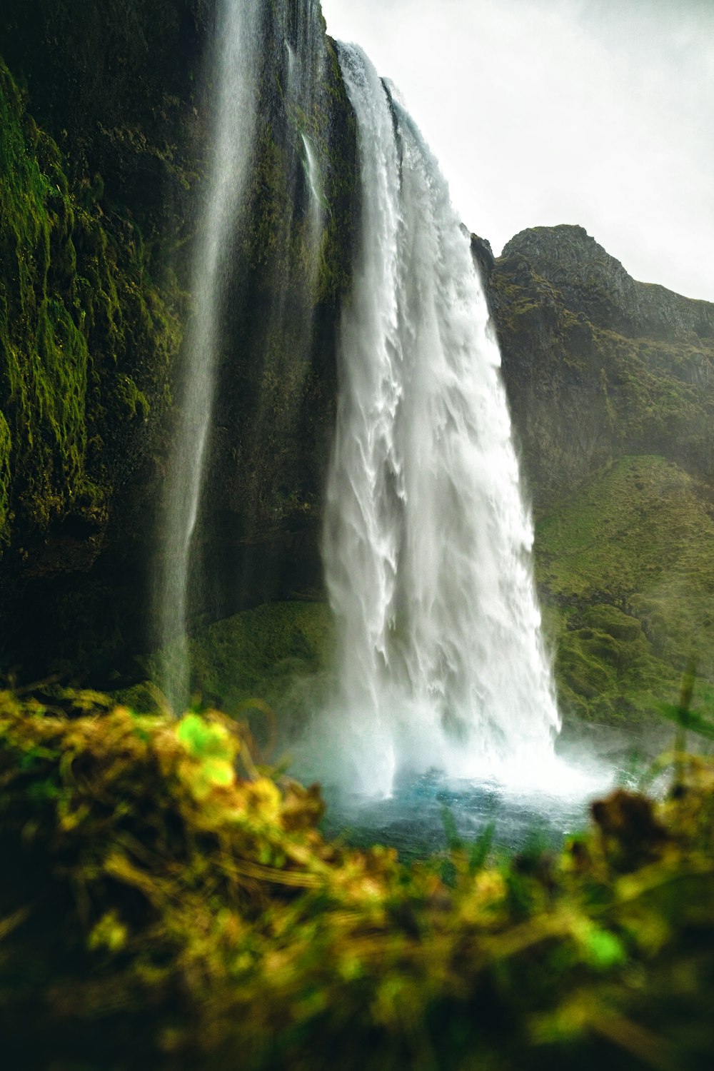 waterfalls on green moss covered rock