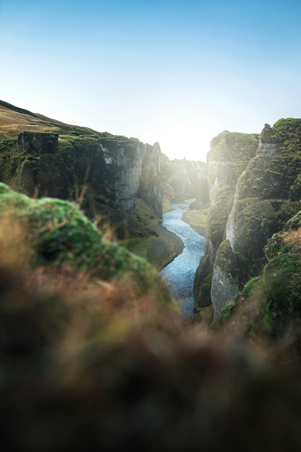 river between green grass covered mountain during daytime