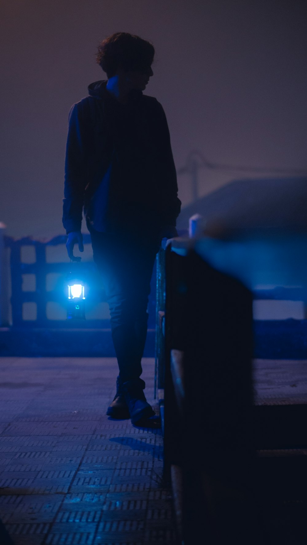 man in black jacket and pants walking on sidewalk during daytime