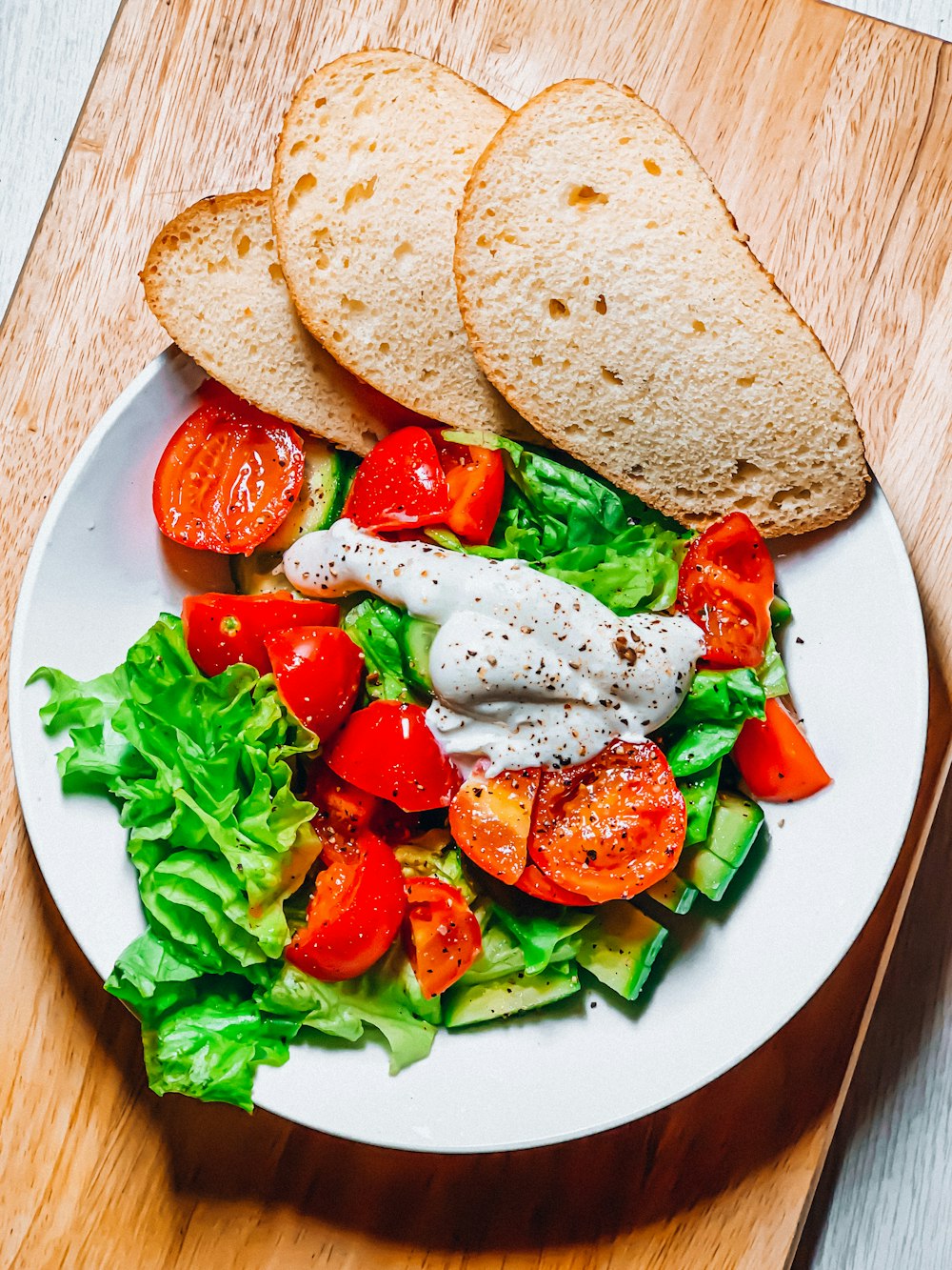 Pain tranché aux légumes verts sur assiette en céramique blanche