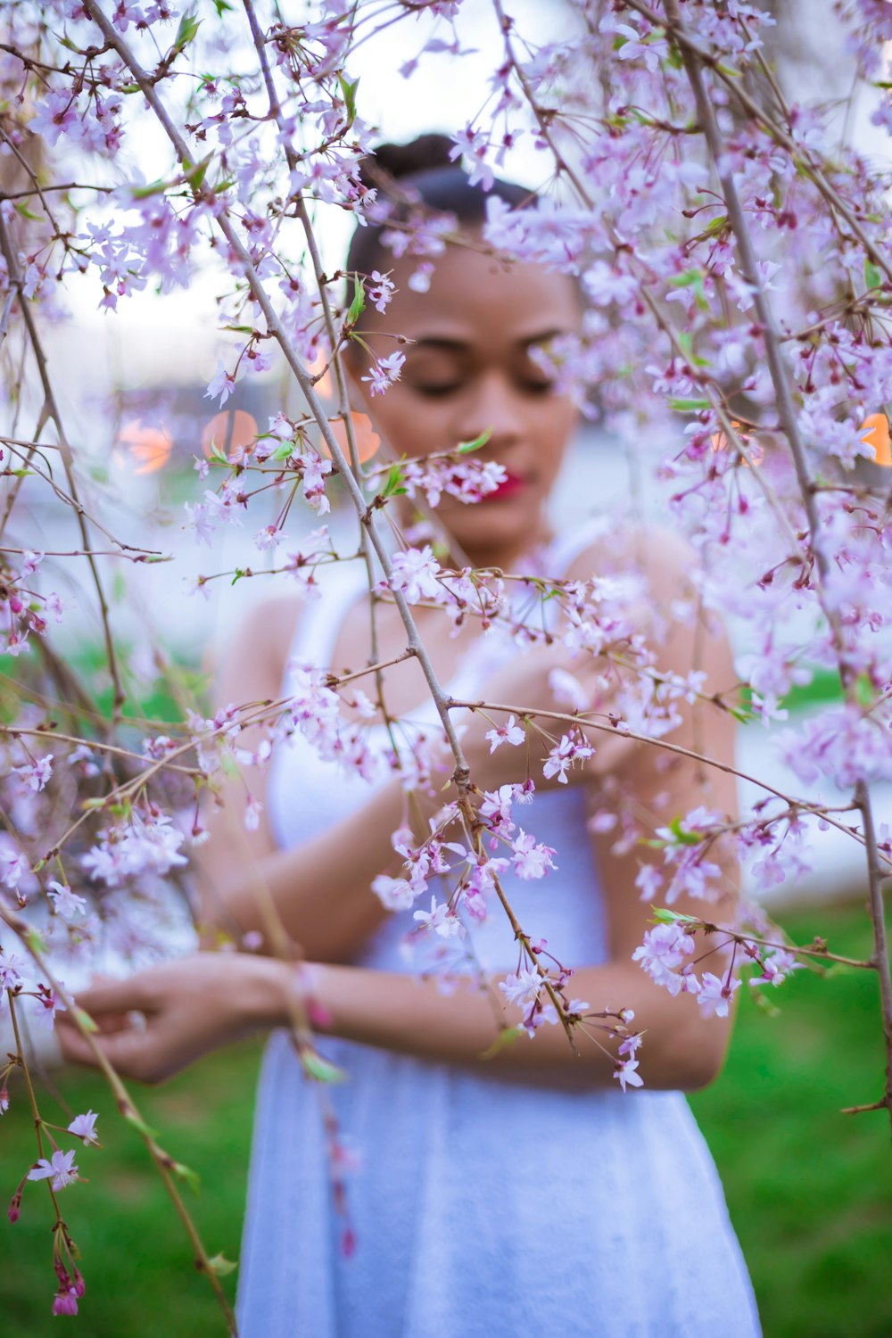 woman in white dress sitting on white flower field during daytime