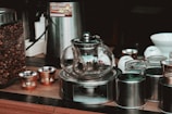 Coffee maker and tea set arranged neatly on a side table.
