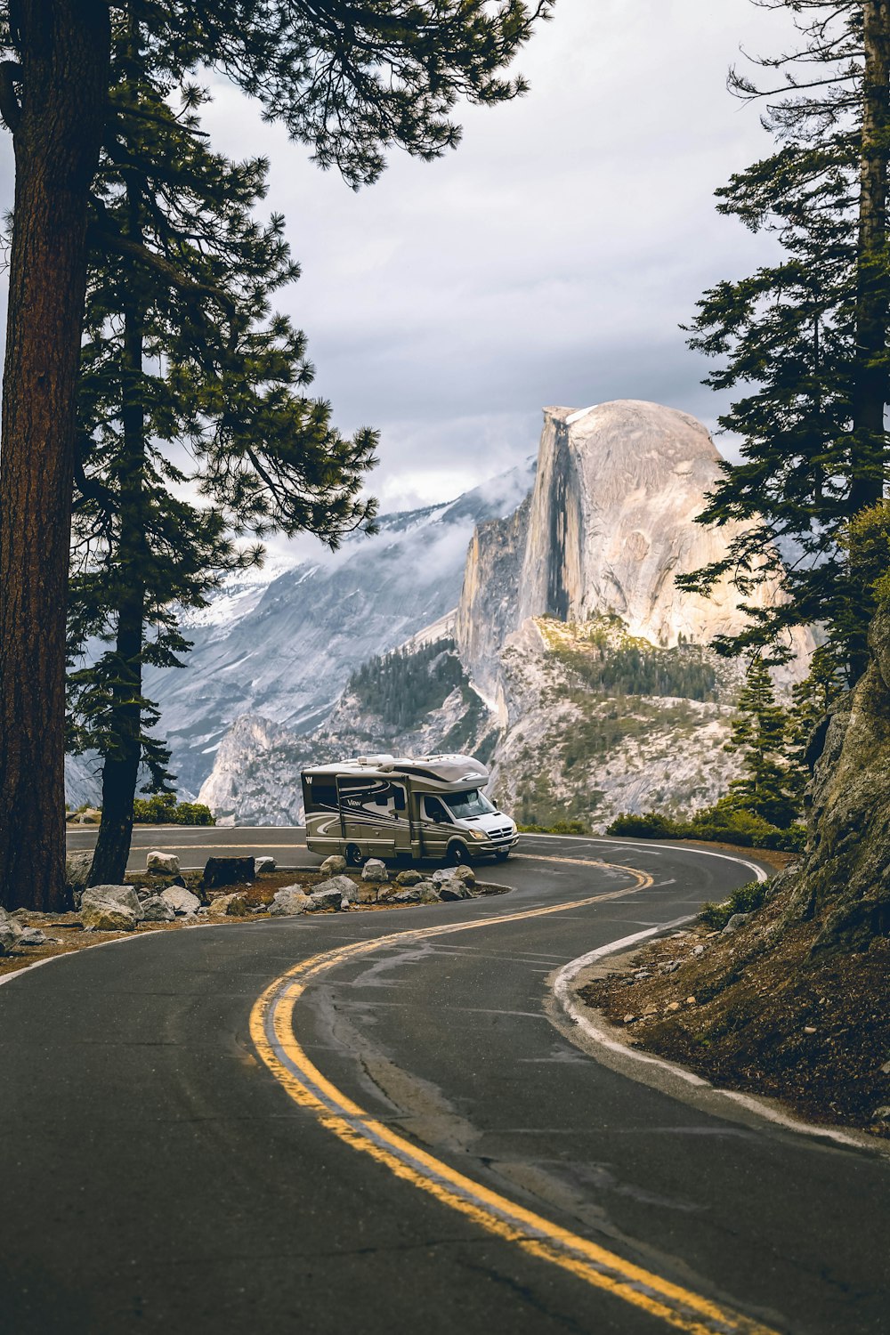 black suv on road near trees and snow covered mountain during daytime