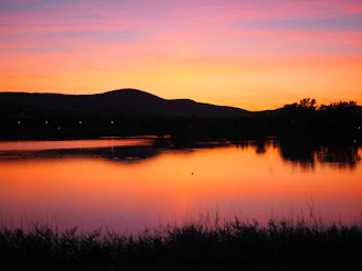 Vibrant acrylic painting of a sunset over a tranquil lake