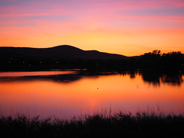 Vibrant acrylic painting of a sunset over a tranquil lake