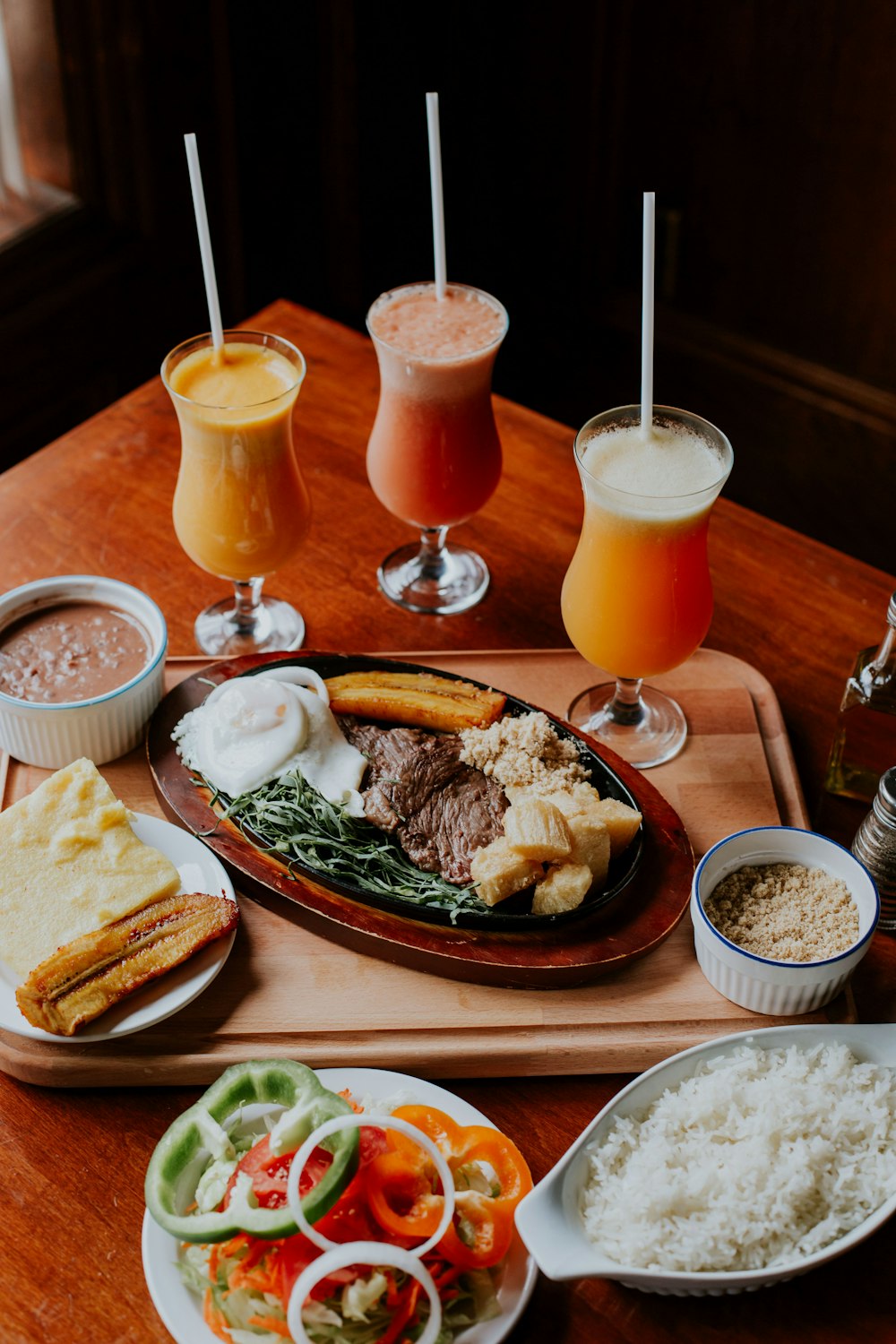 two orange juice in drinking glasses on brown wooden table