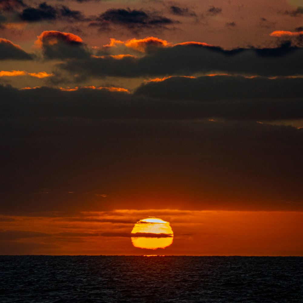 body of water under cloudy sky during sunset