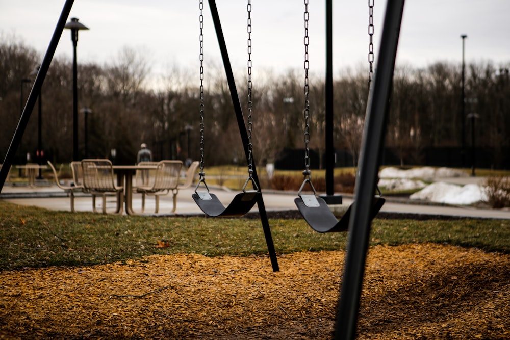 black metal swing on brown field during daytime