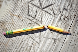 yellow pencil on gray wooden surface