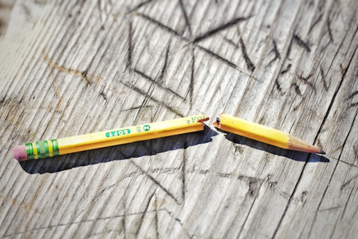 yellow pencil on gray wooden surface