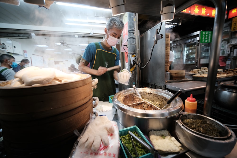 man in green apron cooking food