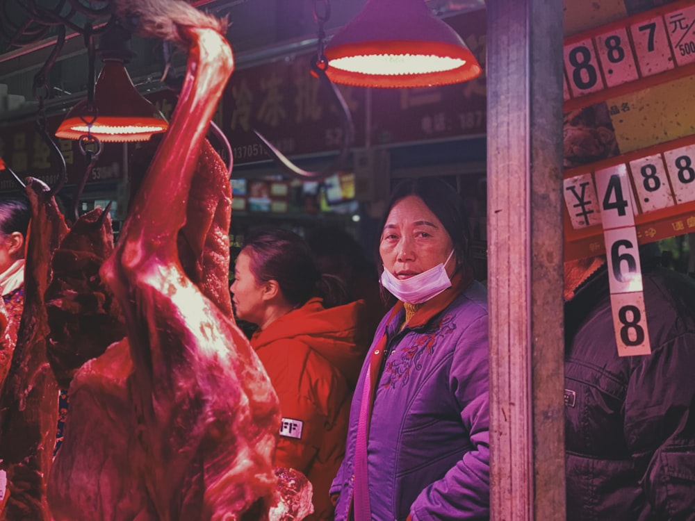 man in red jacket holding raw meat