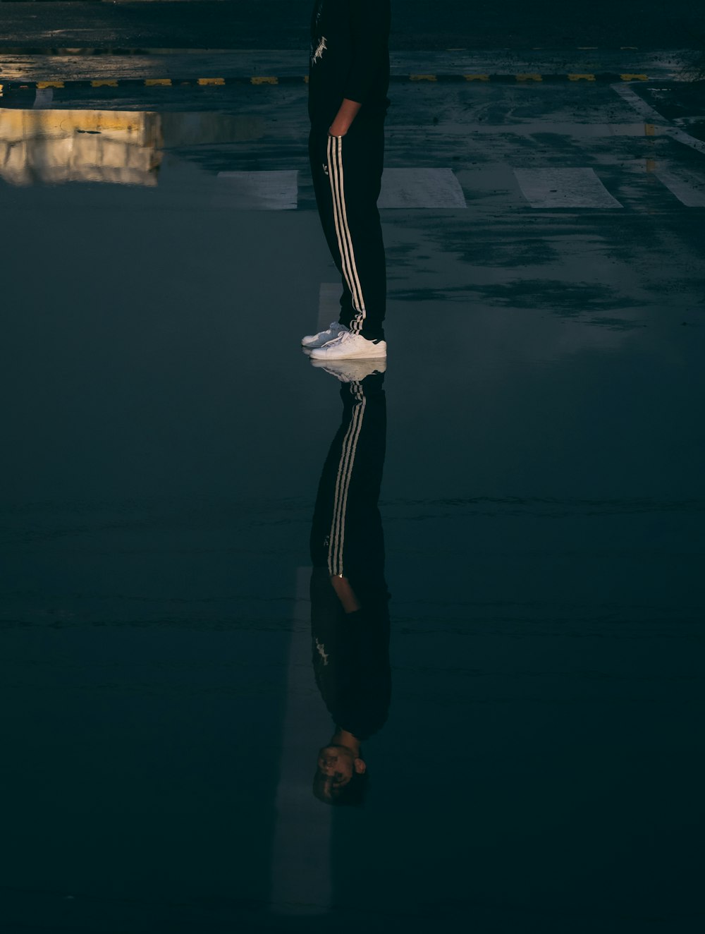 woman in black pants and white long sleeve shirt standing on gray concrete floor during daytime