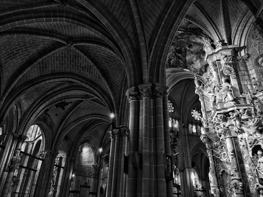 gray scale photo of cathedral interior in Catedral Primada de Toledo Spain