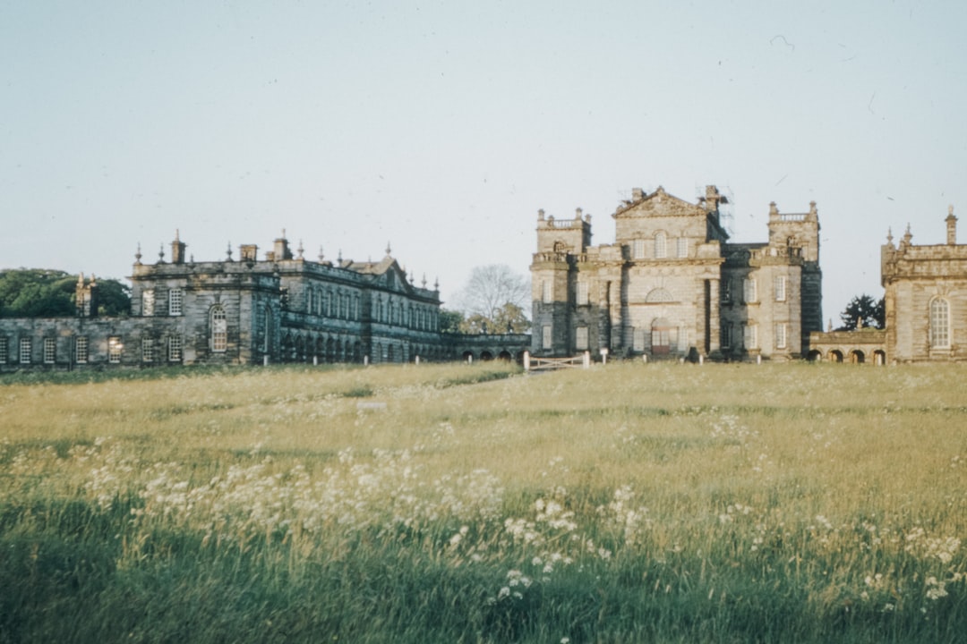 brown concrete building near green grass field during daytime, 1970s 35mm film slide photo