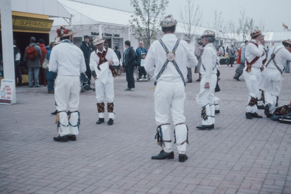 Homme en gi de karaté blanc et pantalon blanc debout sur un sol en béton gris pendant la journée