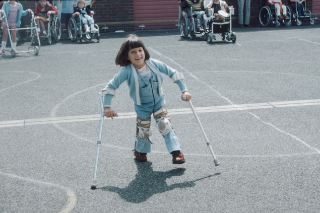 girl in blue and white striped long sleeve shirt and blue denim jeans holding walking stick