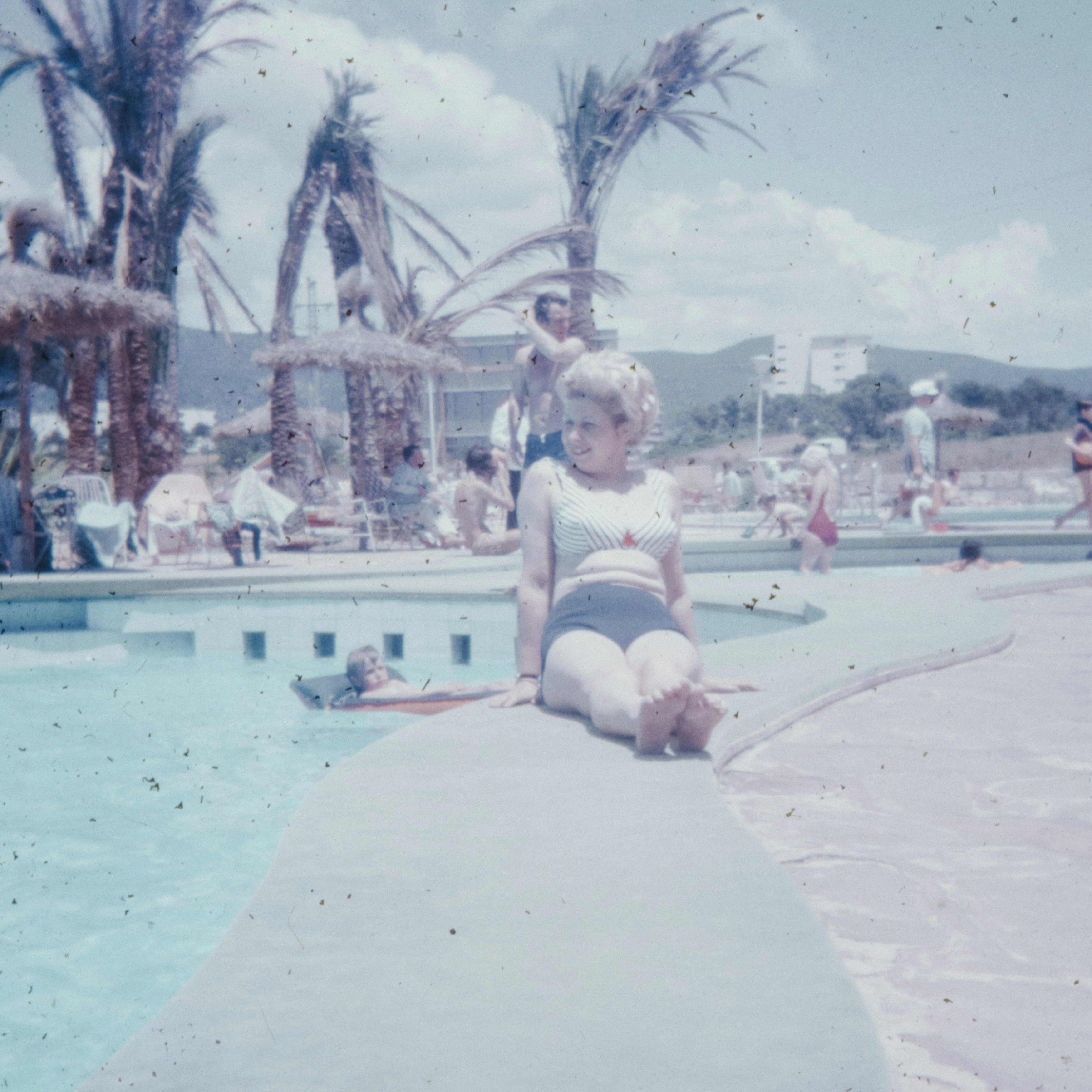 woman in white sports bra and white panty sitting on gray concrete bench near swimming pool