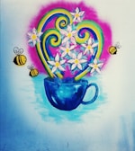 A colorful wall mural features a vivid blue cup filled with white flowers. Yellow bees with black stripes are flying around the flowers. Swirling green and yellow decorative elements add to the lively composition, all set against a pink backdrop with a soft blue base.
