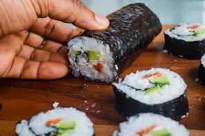 A close-up of a sushi roll being sliced with precision.