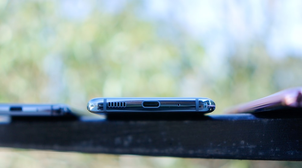 blue and silver smartphone on black table