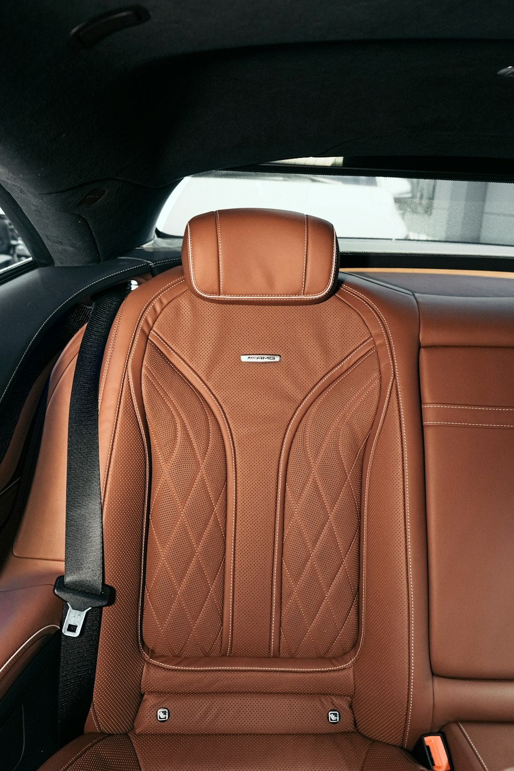 Mochila de cuero marrón en el asiento del coche