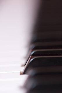 A close-up photo of piano keys with soft natural light highlighting the texture.