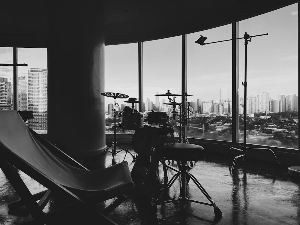 grayscale photo of people sitting on chairs near body of water