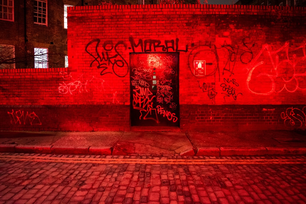 red and black brick wall with graffiti