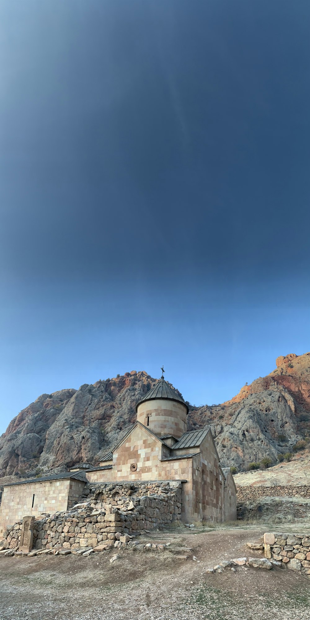 brown and gray concrete building on brown rocky mountain under blue sky during daytime