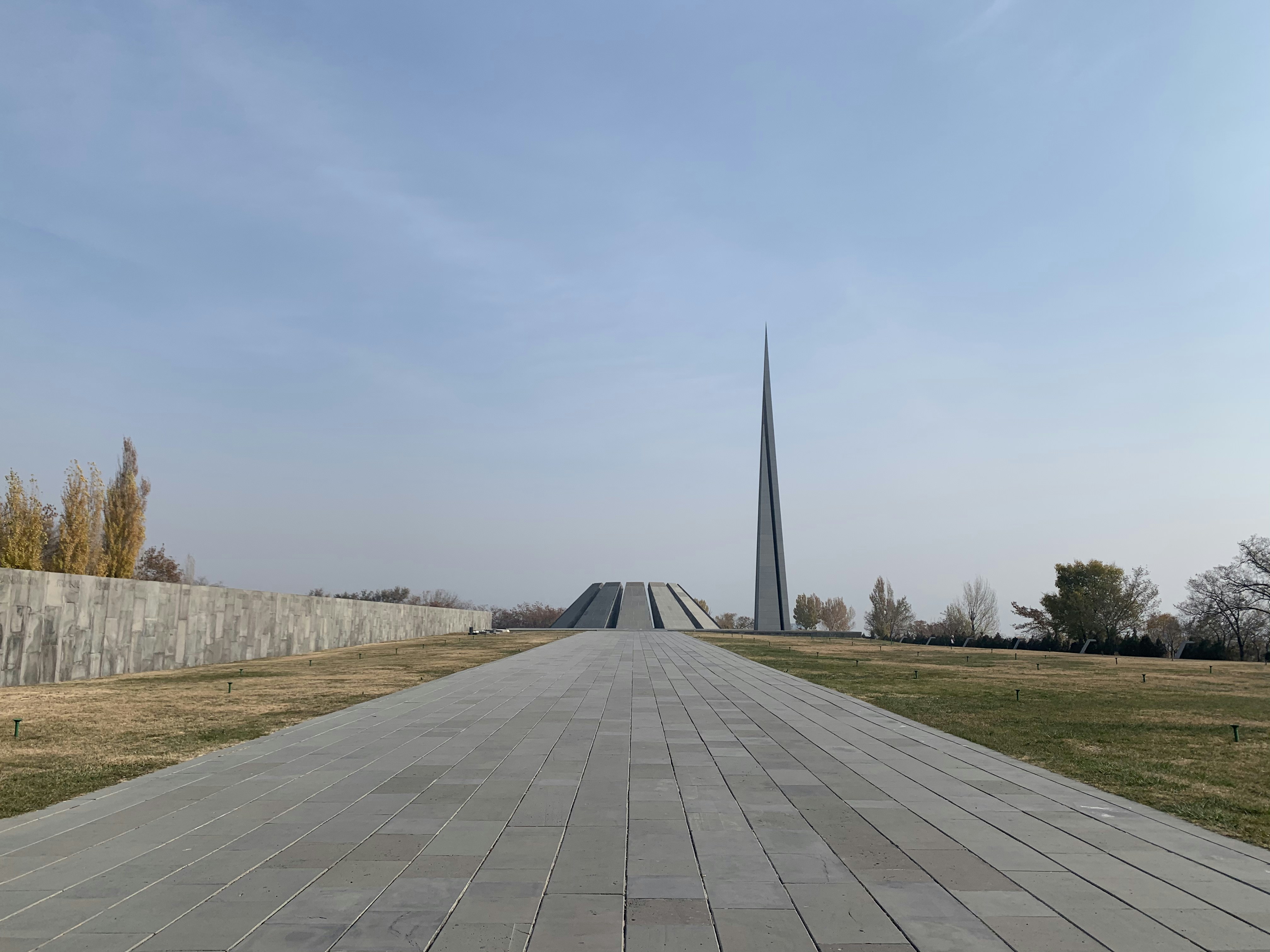 Gray concrete pathway between green grass field under white sky during ...