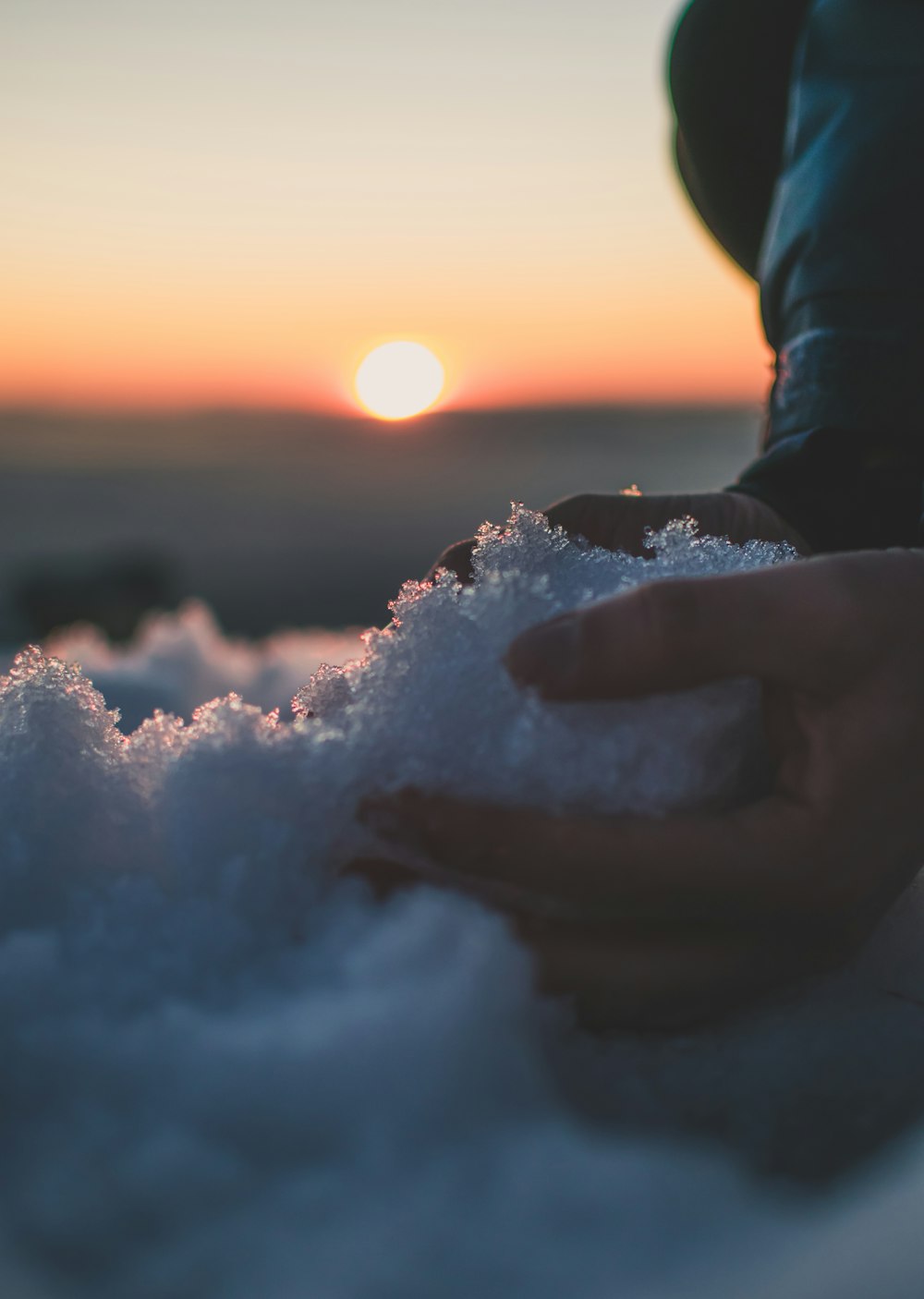 Person, die während des Sonnenuntergangs weißen Sand hält