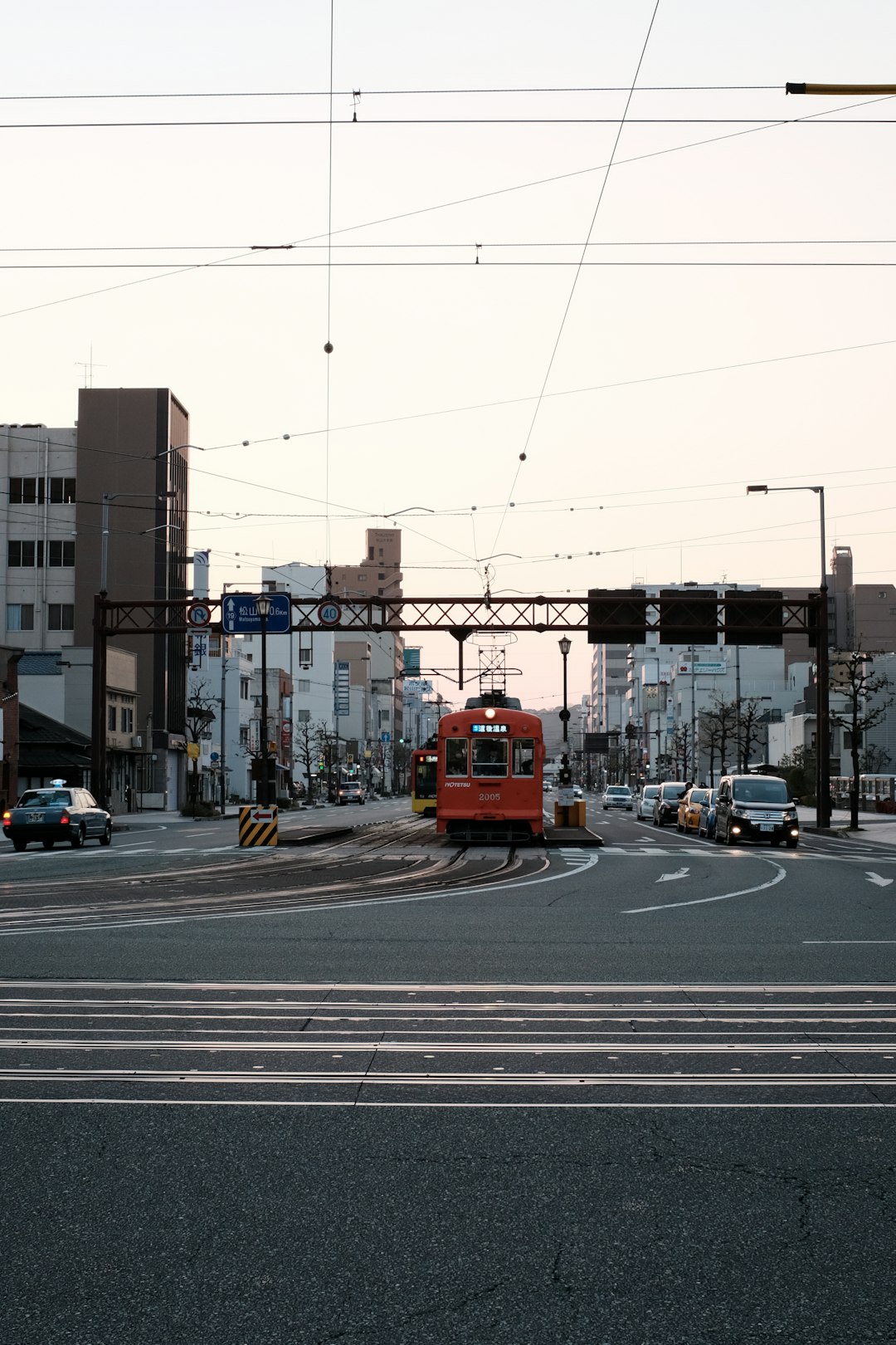 red tram on road during daytime