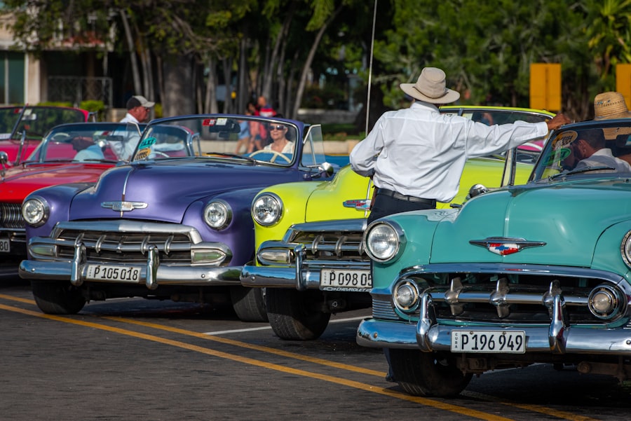 Hombre con sombrero conduciendo auto verde clásico por calle de La Habana, Cuba — transporte y movilidad