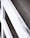 A close-up view of a textured concrete surface with evenly spaced circular indentations. A partial view of white painted metal railings runs diagonally across the image.