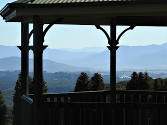 white wooden fence near green mountains during daytime