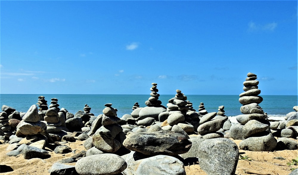 Rocas grises y negras cerca del cuerpo de agua durante el día